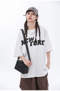 Close-up of a black square crossbody box bag paired with a casual streetwear outfit