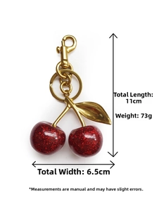 Detail view of glitter resin cherry keychain with gold metal leaf and 11cm dimensions