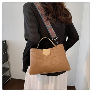 Brown handbag detail with geometric triangle pattern and colorful ethnic crossbody strap