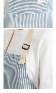 Detail of blue striped kitchen apron featuring a large front pocket and adjustable strap