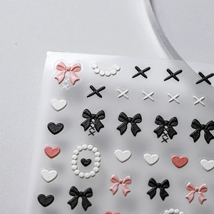 3D embossed nail art stickers featuring bows, pearls, and hearts in black and pink colors