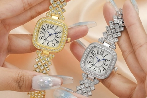 Gros plan de montres carrées avec strass en finitions or et argent sur soie
