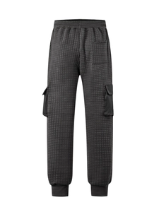 Close-up of quilted jacquard fabric texture and cargo pockets on dark grey joggers