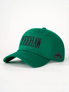 Close-up of embroidered YEEHAW text and cowboy silhouette on green cotton baseball cap