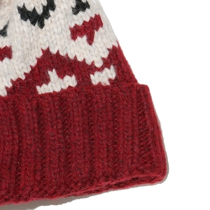 Detailed close-up of thick knit mohair beanie with red and white geometric diamond pattern