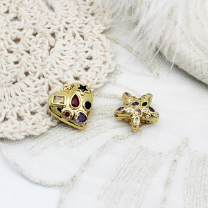 Macro shot of 18K gold plated heart and star pendants with colorful zircon inlays