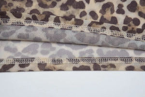 Detail shot of leopard print mesh fabric with high-quality double-stitch sewing finish