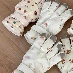Detail of windproof ski gloves featuring cartoon prints and adjustable velcro straps