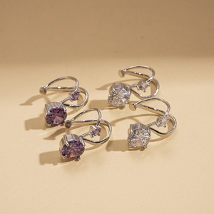Silver-tone double-layered zircon ear cuff set in purple and white on beige surface