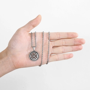 Detailed view of silver Viking Vegvisir compass pendant on palm for size reference