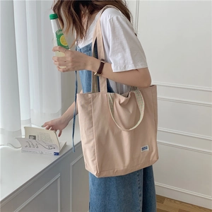 Bolso tote minimalista de lona beige con detalles de cuadros en el asa para uso diario