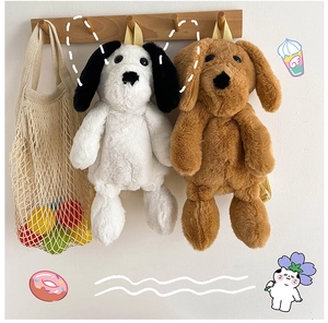 Close-up of cute plush dog backpacks in black-white and brown with fuzzy texture
