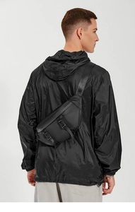 Detail of black utility chest bag with adjustable strap and buckle on a model's back