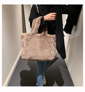 Détail d'un grand sac cabas en peluche marron avec fausse fourrure douce porté par un mannequin