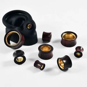 Detailed view of wood and gold ear flesh tunnels in multiple sizes on white background