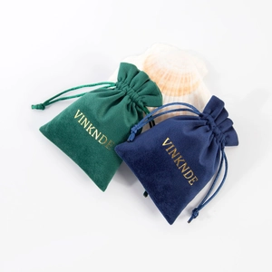 Detailed view of velvet drawstring jewelry pouches in navy blue and emerald green