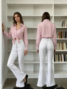 Détail du jean évasé blanc à taille haute boutonnée avec une chemise à rayures roses