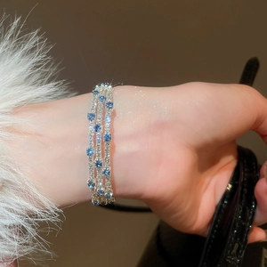 Detail of three-row tennis bracelet with shimmering blue and white cubic zirconia