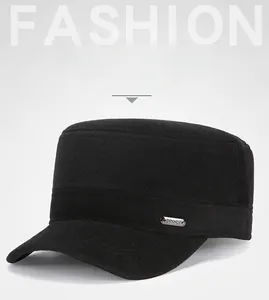 Detail of black wool winter military cap featuring a metal logo plaque and thick warm lining