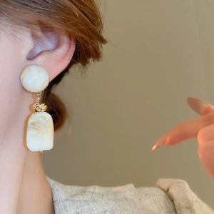 Detail of irregular marble resin earrings with vintage gold metal twist connectors