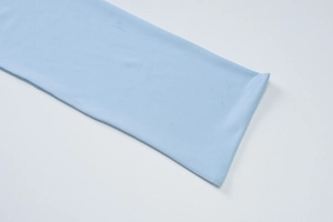 Dettaglio ravvicinato del tessuto in pizzo celeste e delle cuciture di questo vestito