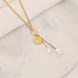 Close-up of gold stainless steel necklace with shell pendant and pearl tassels detail