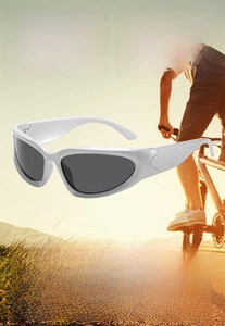 Close-up of white futuristic sports sunglasses with grey lenses for cycling at sunset