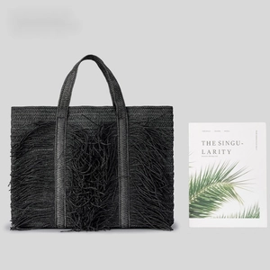 Handwoven black straw tote bag with long fringe tassels for beach holidays and summer travel