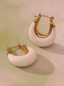 Detailed close-up of U-shaped gold earrings with smooth white resin inlay and 18K plating