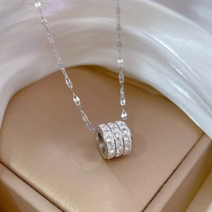 Macro detail of silver titanium steel necklace featuring a crystal-studded cylinder pendant