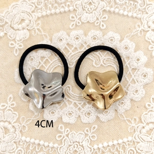 Detail of 4cm gold and silver star metal charms on black high-elastic hair ties