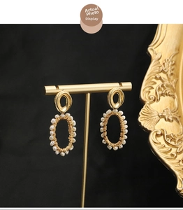 Detailed macro shot of vintage gold wire-wrapped earrings with elegant round white pearls