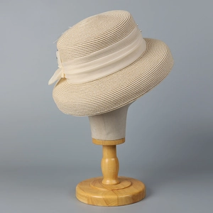 Elegant beige straw cloche hat with chiffon bow ribbon and pearl accents for summer sun