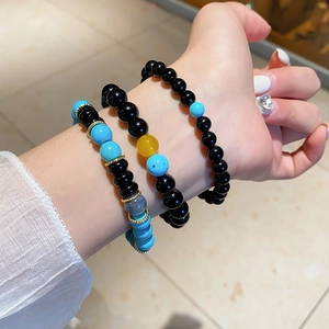 Close-up of stacked beaded bracelets with turquoise and agate stones on a wrist