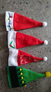 Detail of assorted mini Christmas hats featuring Santa and elf designs for cutlery sets