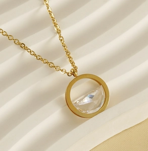 Detail of 18K gold-plated necklace with a transparent heart-shaped zircon pendant