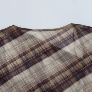 Detailed view of brown plaid mesh fabric neckline with high quality stitching and texture