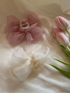 Detailed view of pink and white chiffon butterfly hair claws with tulips on linen fabric