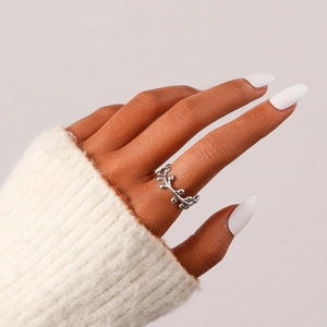 Nahaufnahme eines silbernen Ast-Rings, getragen zu einem weißen Strickpullover