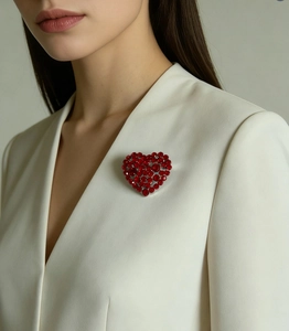 Close-up of elegant red heart rhinestone brooch pinned on a white blazer lapel