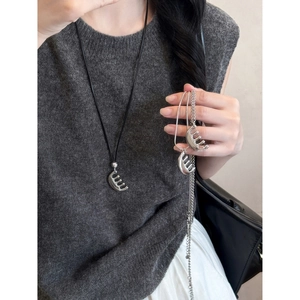 Détail du collier pendentif peigne argenté avec cordon noir et chaîne en métal