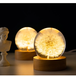 Detailed close-up of a 3D dandelion crystal ball night light with glowing wooden base