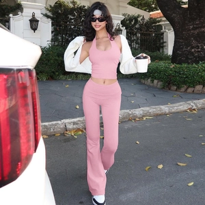 Dettaglio del top rosa e pantaloni a zampa con cardigan in maglia bianca per un look street