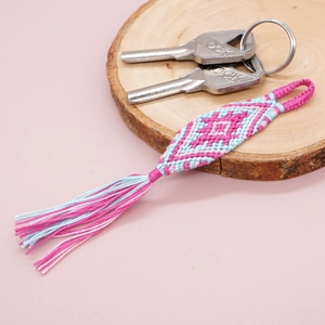 Close-up of pink and blue woven diamond pattern keychain with decorative tassels