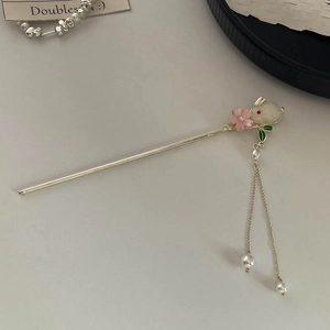 Detail of Chinese gold hair pin featuring a white rabbit charm and pearl tassels