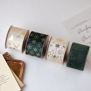 Green and cream Christmas ribbon rolls with gold foil snowflakes and elk patterns