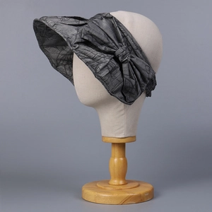 Detail of grey bow sun hat featuring textured tencel fabric and elegant large brim design
