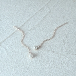 Detail of 925 silver earring with dangling freshwater pearl and sparkling diamond accents