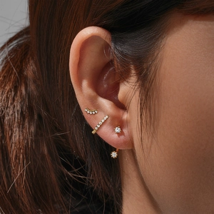 Detailed view of 925 sterling silver evil eye gold earring set on female ear