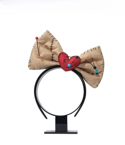 Macro detail of Voodoo doll headband with burlap bow, stitched heart and pins for cosplay